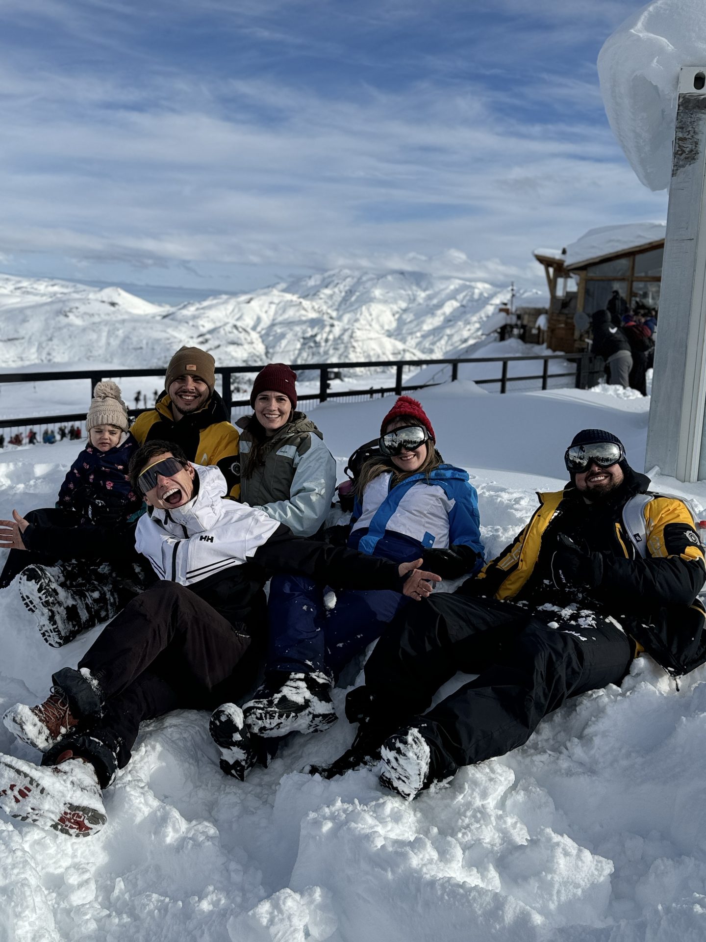 Grupo brasileiro sentado na neve com vista panorâmica dos Andes